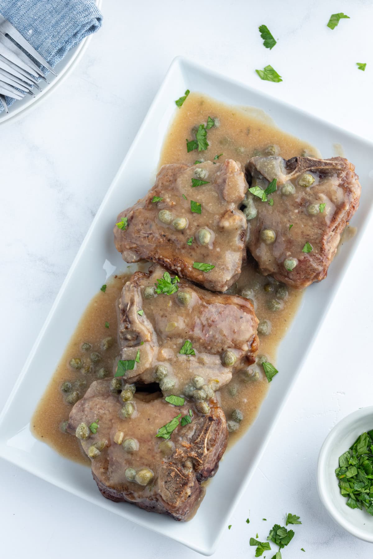 lamb chops in caper sauce on platter