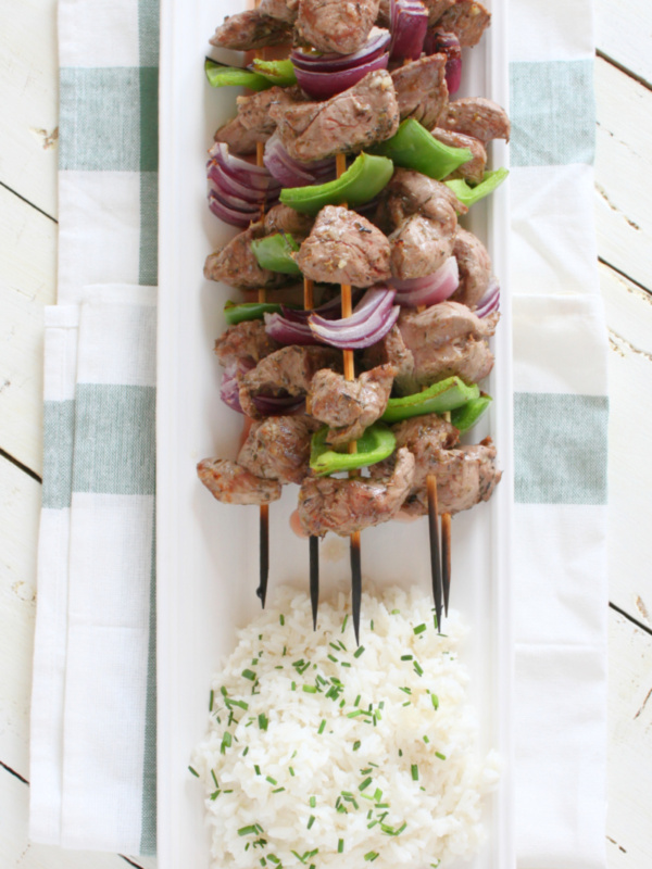 lamb souvlaki with rice on a white platter