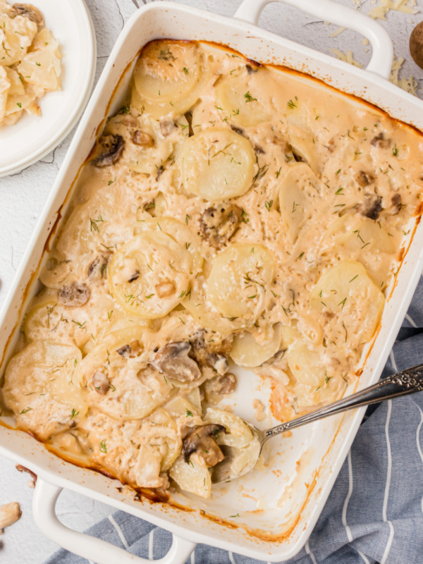 spoon in casserole dish of mushroom dill scalloped potatoes