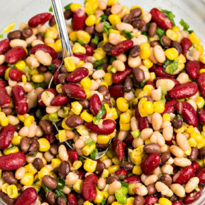 Red White and Black Bean Salad in a glass bowl with a spoon