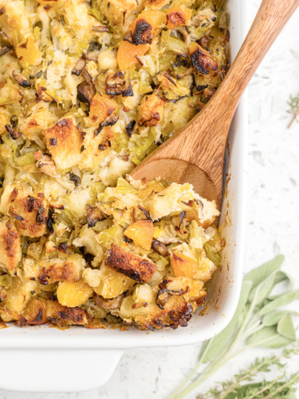 casserole dish of shiitake mushroom stuffing with wooden spoon