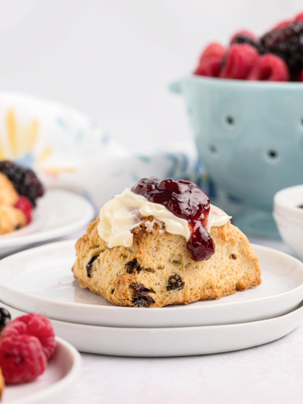 scone on a plate topped with butter and jam