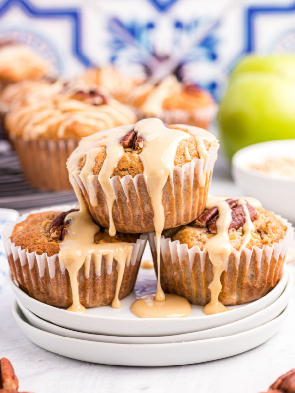 maple drizzled apple muffins stacked on a plate