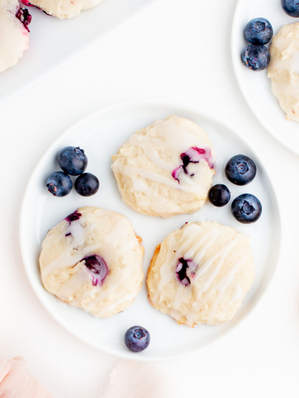 three blueberry cookies on a white plate