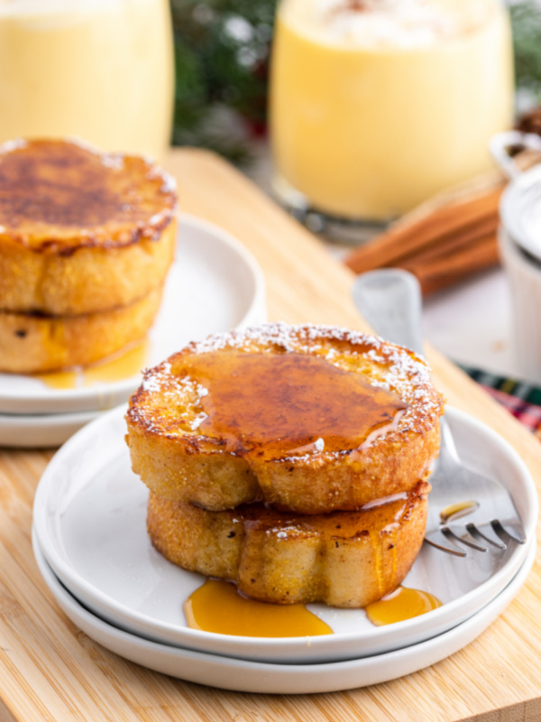 two slices eggnog french toast with syrup on plate