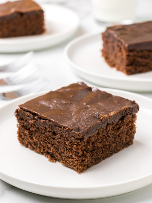 slice of chocolate glazed cake on plate