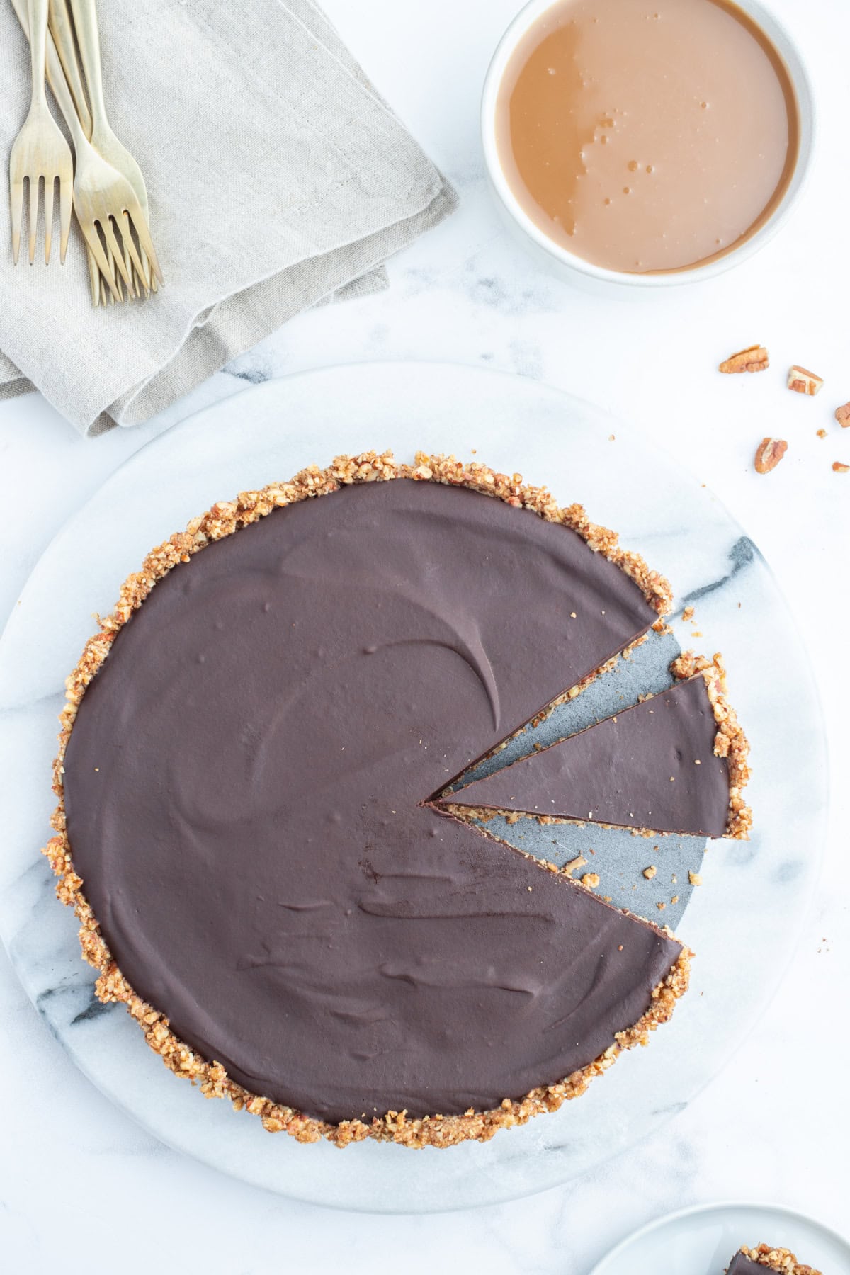 overhead shot of chocolate pecan tart with slice taken out