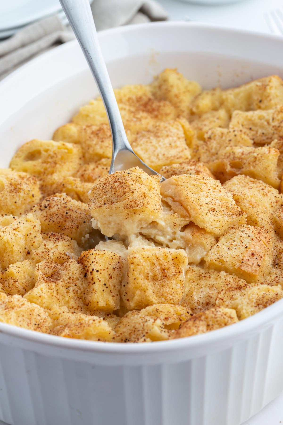 custard bread pudding in a baking dish with spoon