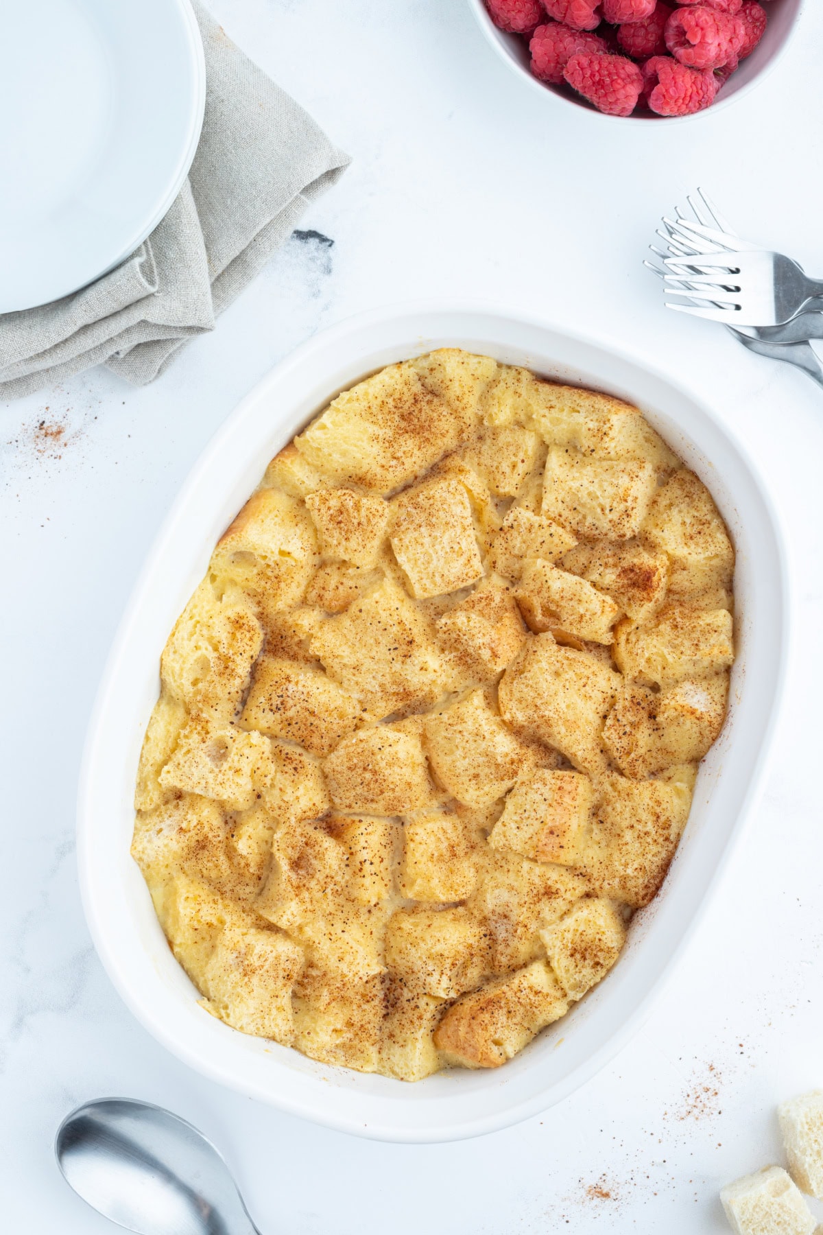 custard bread pudding in an oval white baking dish