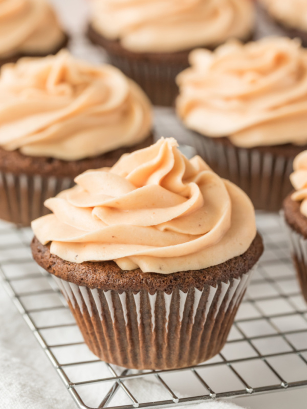 gingerbread cupcakes with pumpkin frosting on rack