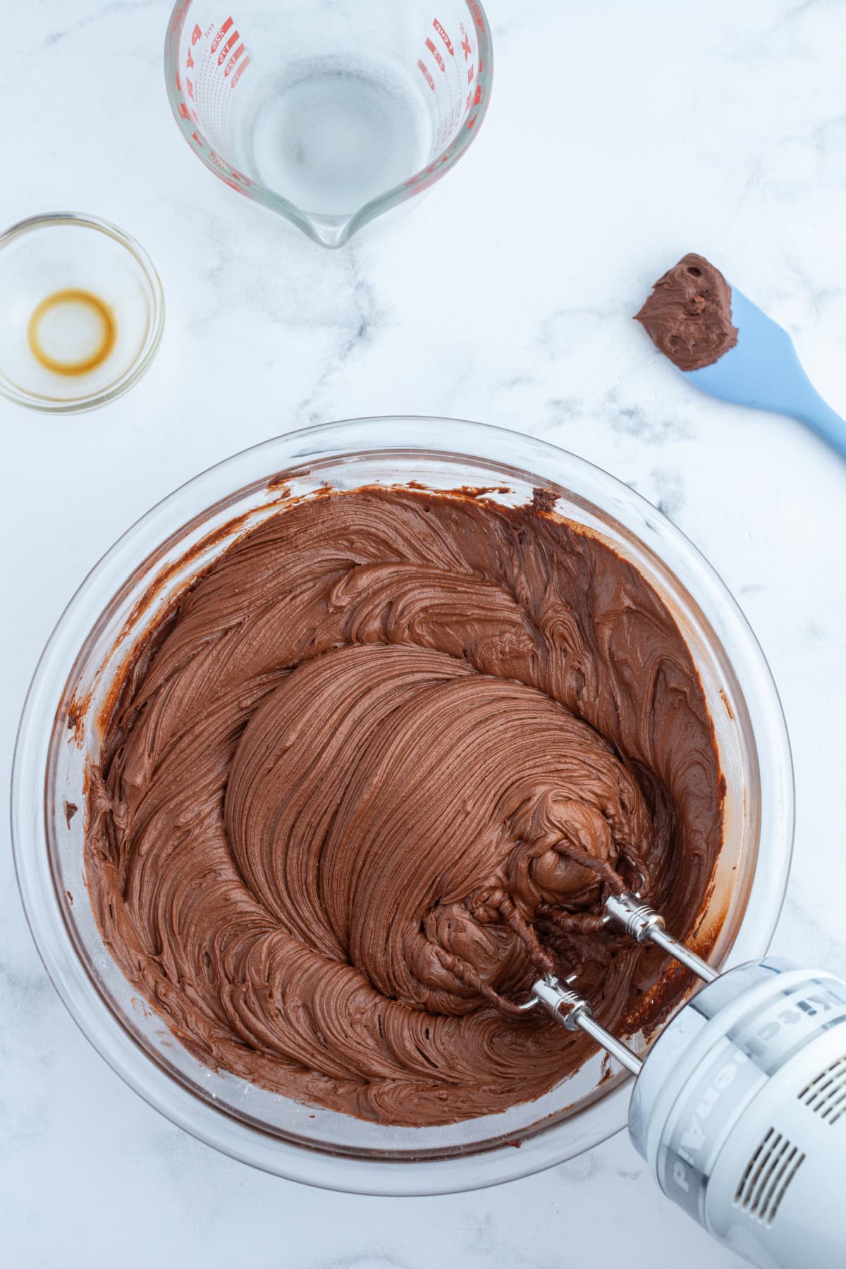 bowl of hershey's chocolate frosting with electric beaters inside