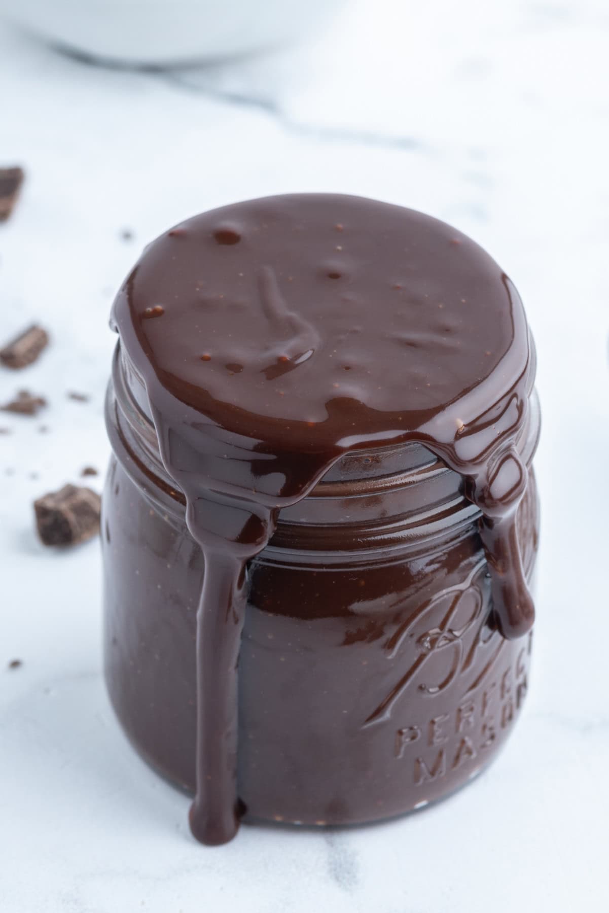 jar of hot fudge overflowing and dripping down sides