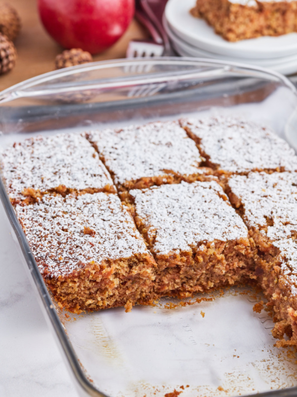 whole grain apple cake in baking pan sliced into pieces