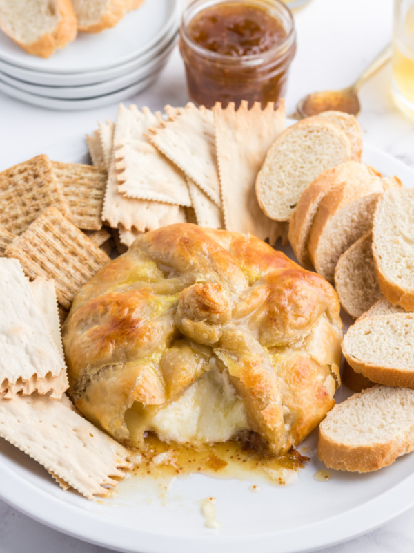 baked brie cut open with oozing cheese and crackers and bread