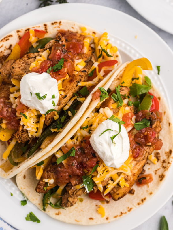 two tortillas stuffed with chicken fajitas on plate