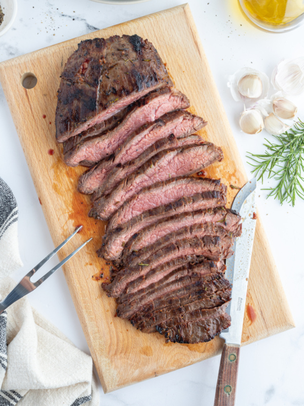 sliced flank steak on a board