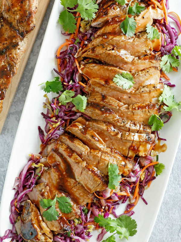 grilled pork tenderloin with hoisin sesame sauce on a white plate