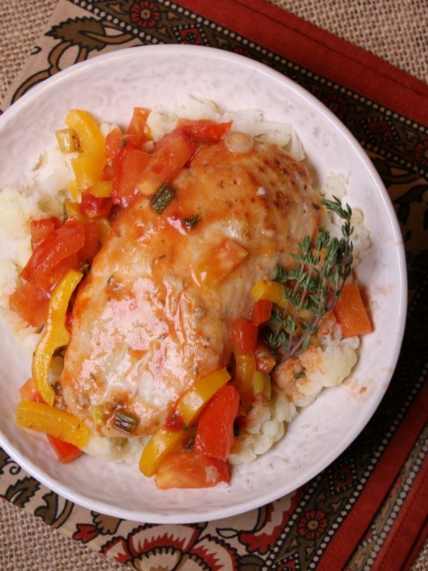 Sauteed chicken with tangy tomato sauce on a white plate