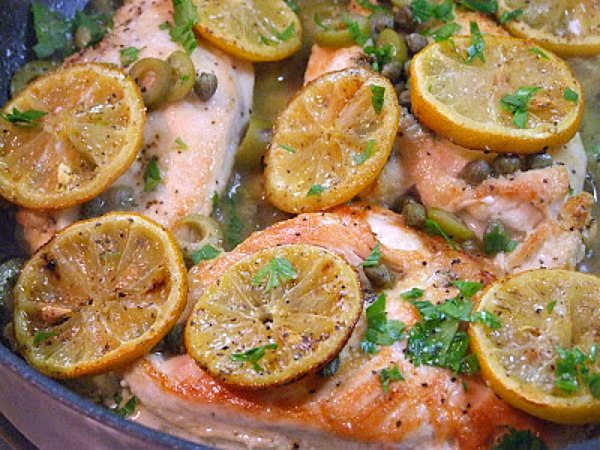 Sauteed Chicken with Olives, Capers and Roasted Lemons on a white plate