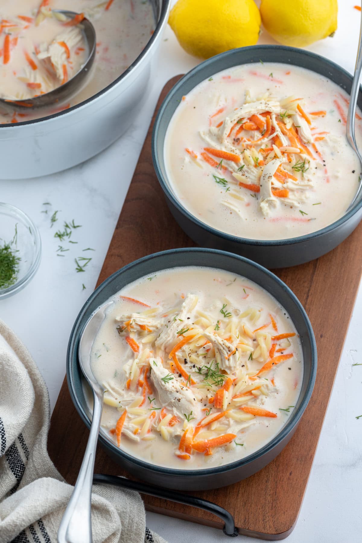 overhead shot of greek orzo and chicken soup in two bowls