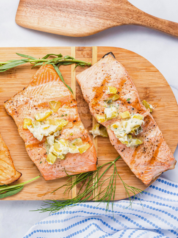 two grilled salmon fillets topped with dill pickle butter