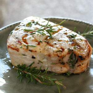 grilled swordfish with rosemary on a gray plate