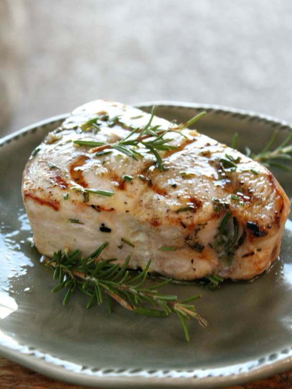 grilled swordfish with rosemary on a gray plate