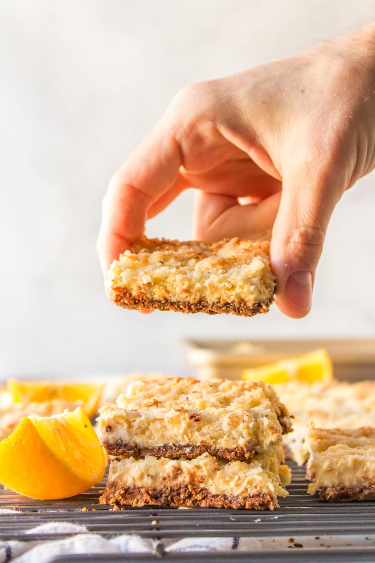 hand holding lemon bar with kit kat crust