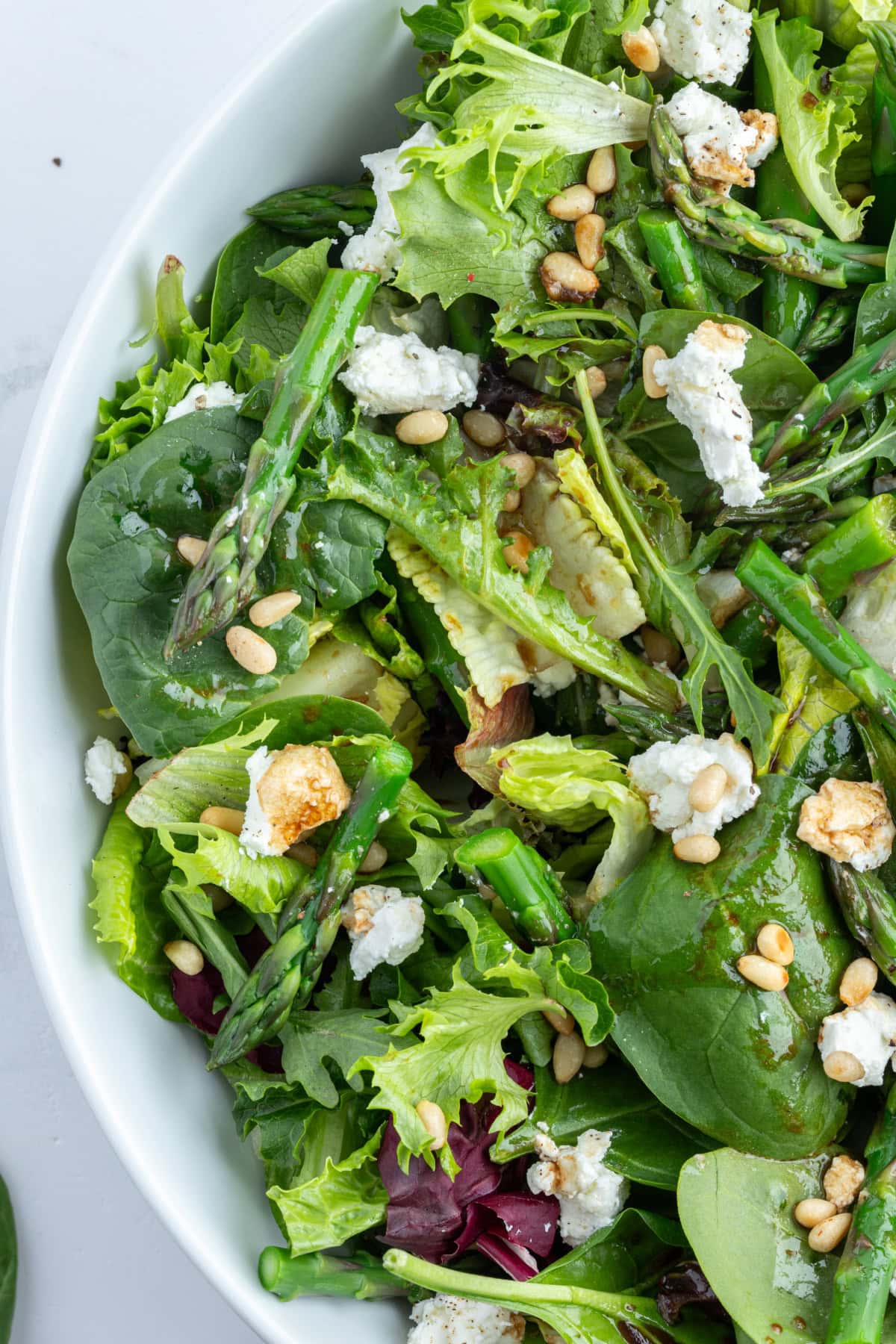 half of a bowl of asparagus and goat cheese salad