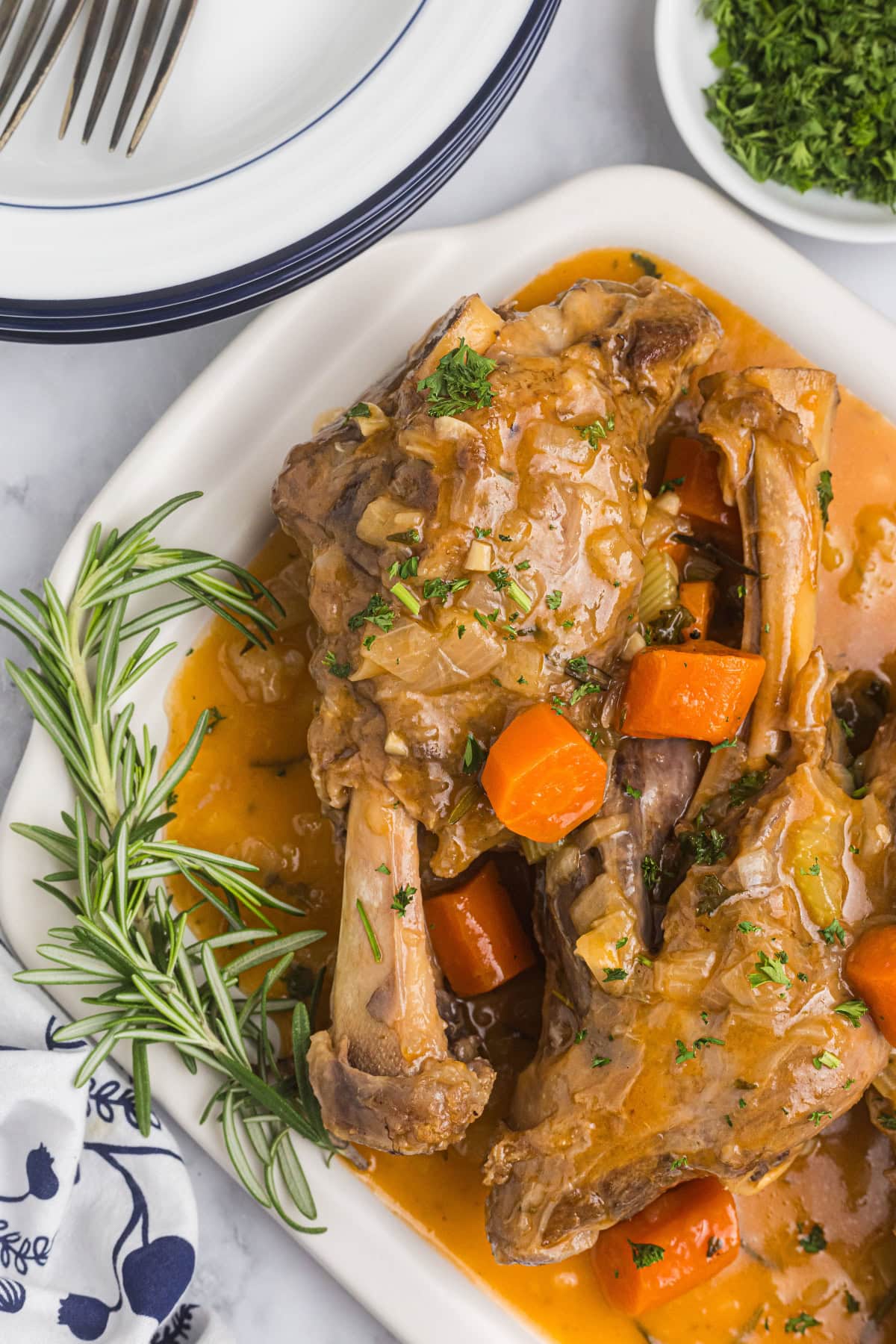 braised lamb shank with rosemary on platter