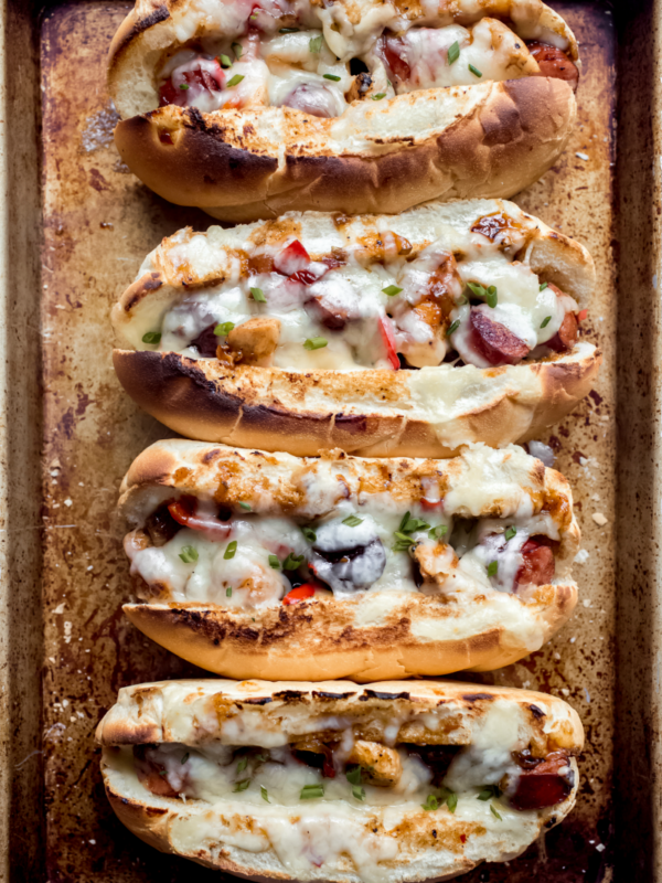 four chicken and sausage hoagies on a baking sheet