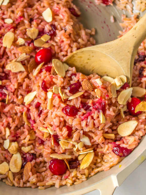 wooden spoon in pot of cranberry rice pilaf