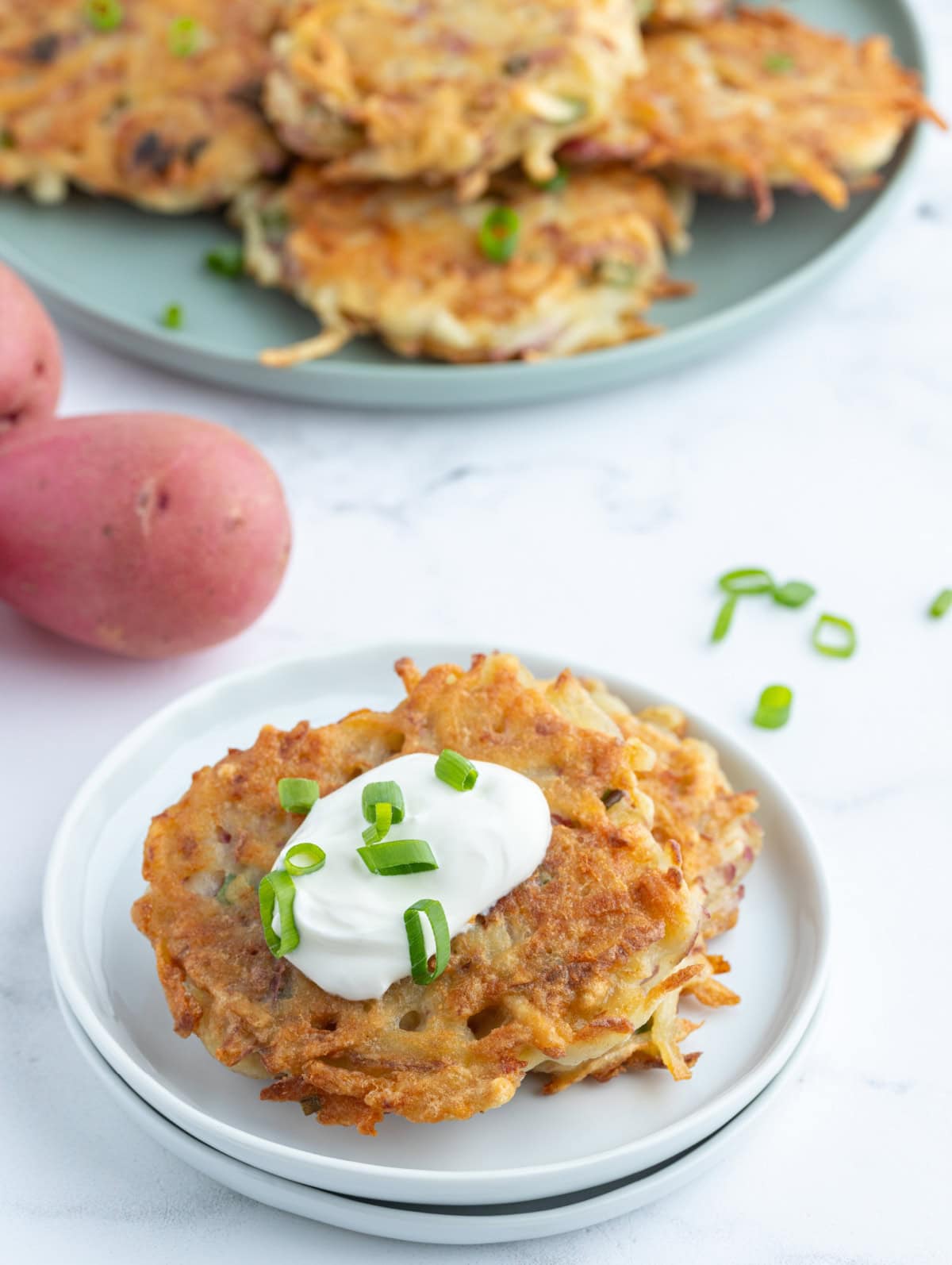 crispy potato pancakes on plate with sour cream