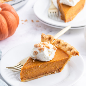 slice of dulce de leche pumpkin toffee pie on a plate topped with whipped cream