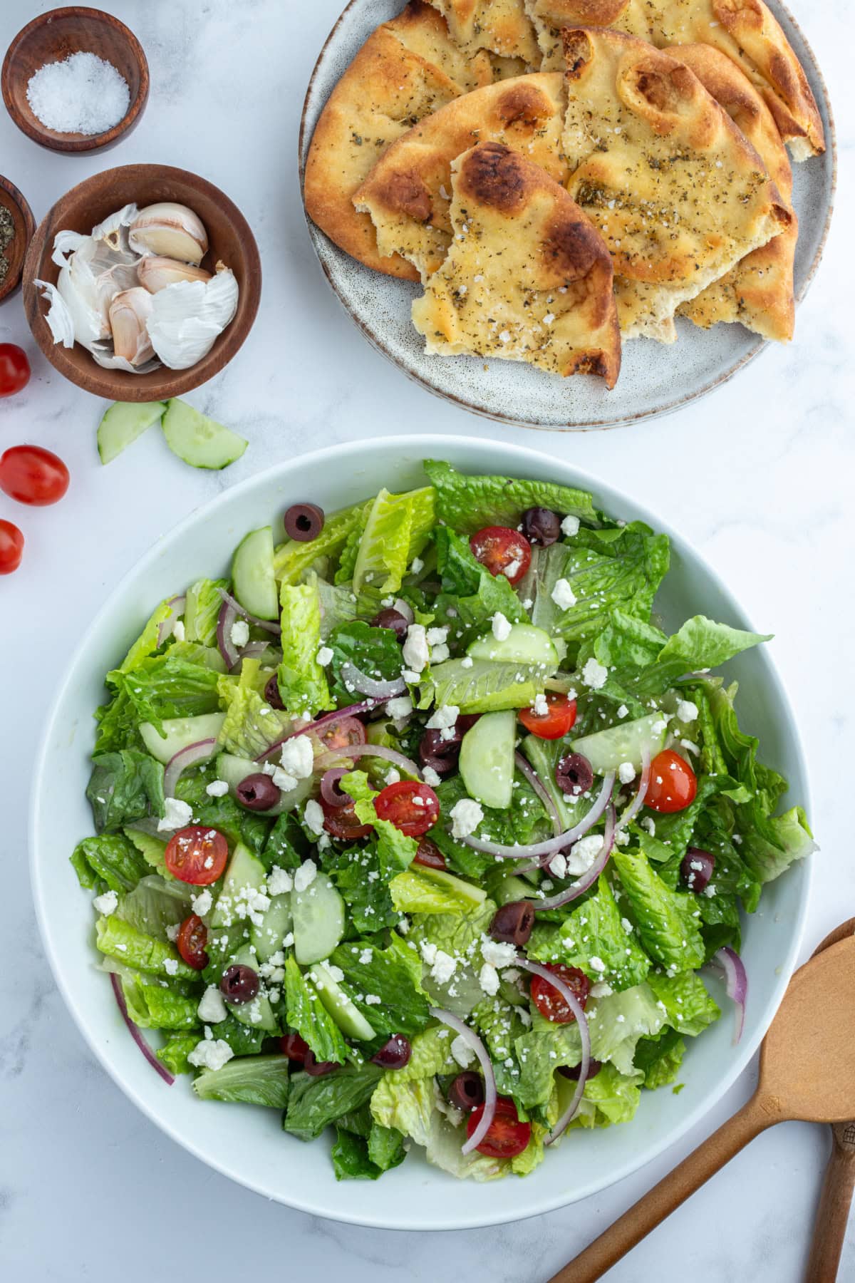 bowl of greek salad with seasoned flatbread on the side