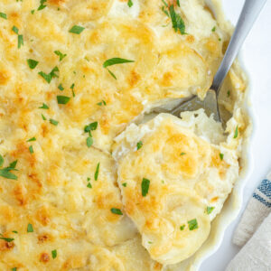 potato leek gratin in a casserole dish with a spoon