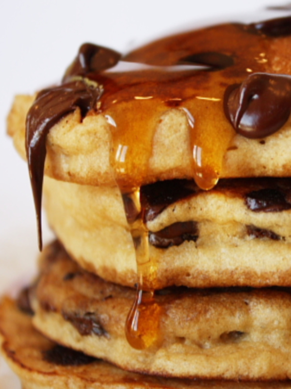 stack of chocolate chip pancakes with syrup dripping off