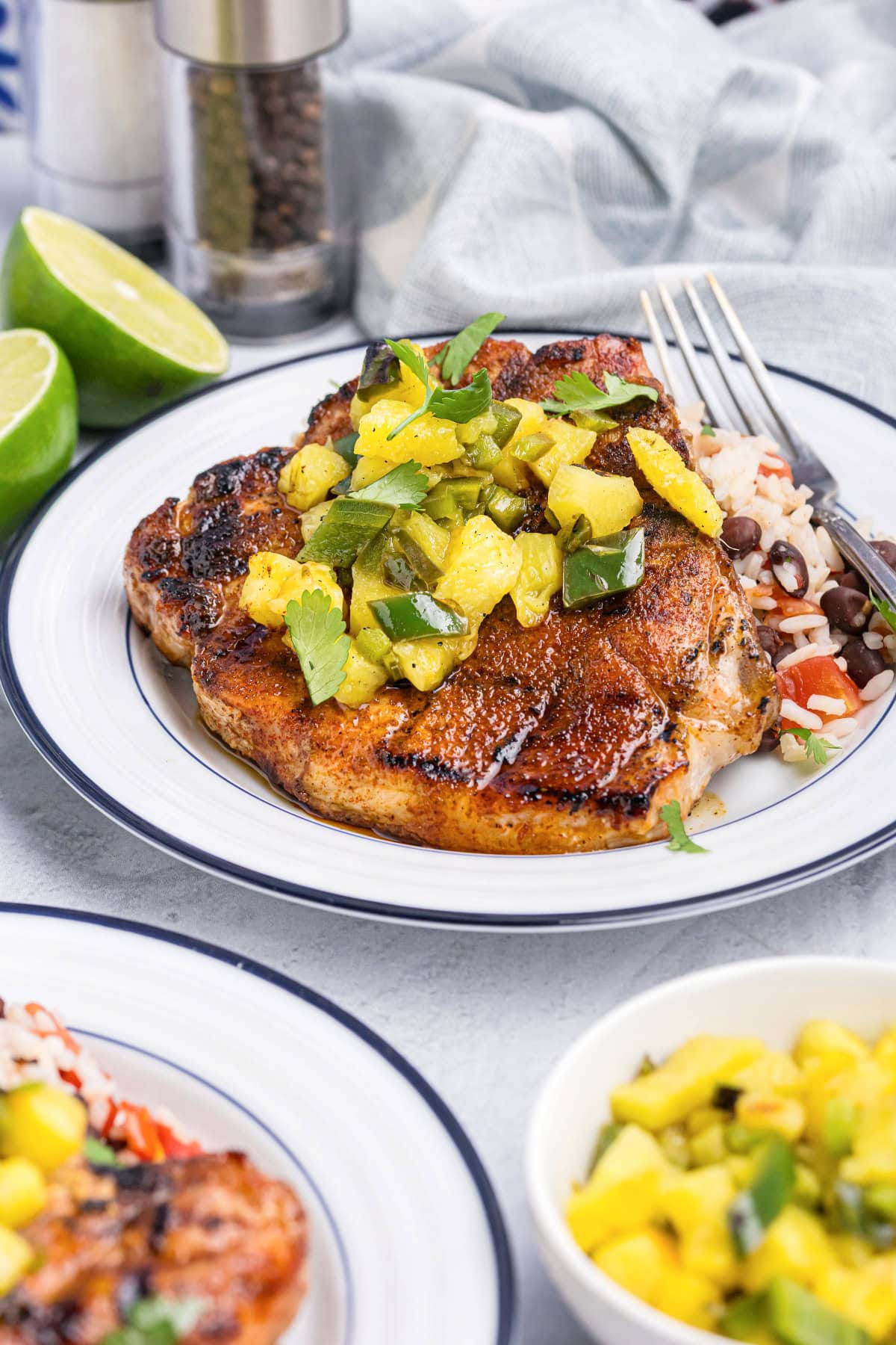 Chili rubbed pork chop topped with pineapple salsa on plate