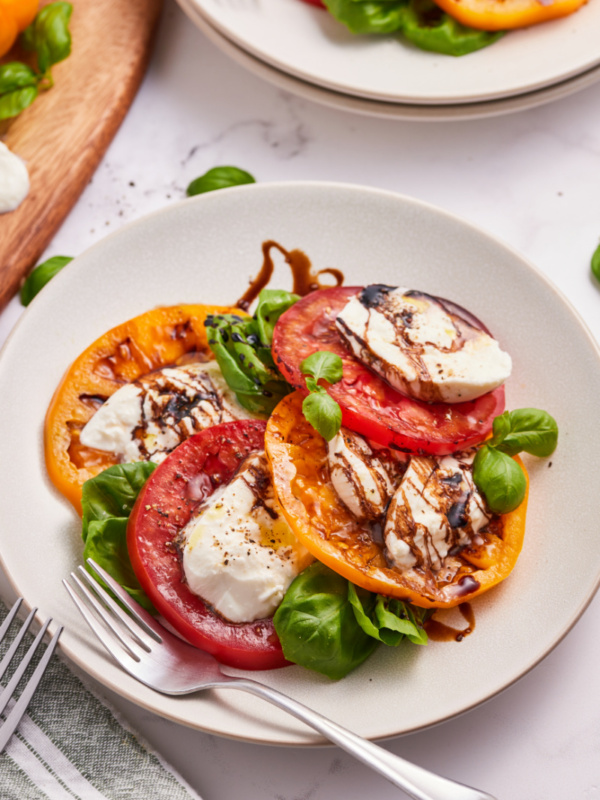 caprese salad with burrata cheese on a white plate