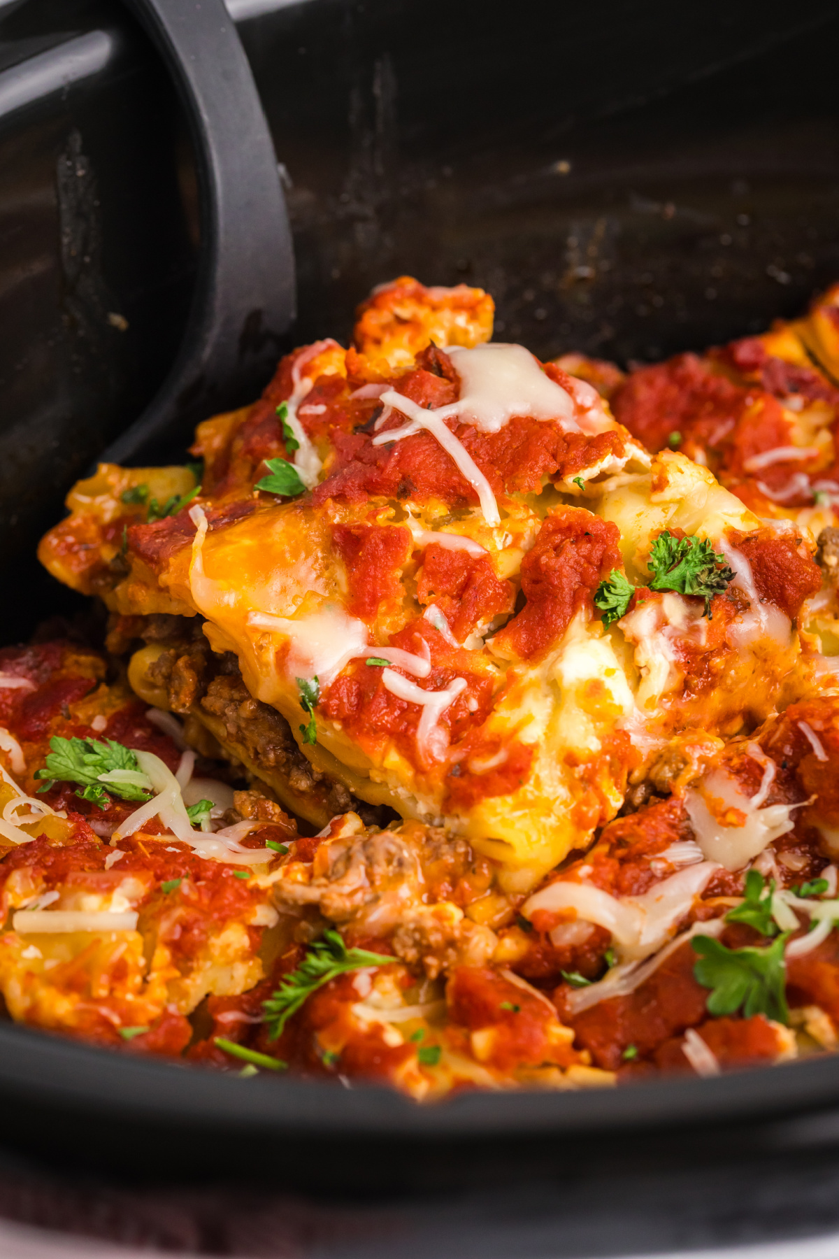 spatula taking slice of lasagna out of slow cooker