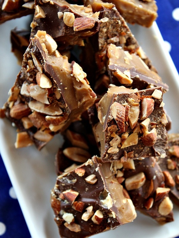 almond roca on a white plate sitting on a blue and white polka dot napkin