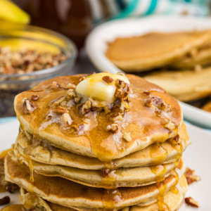 stack of banana pecan pancakes with butter and syrup