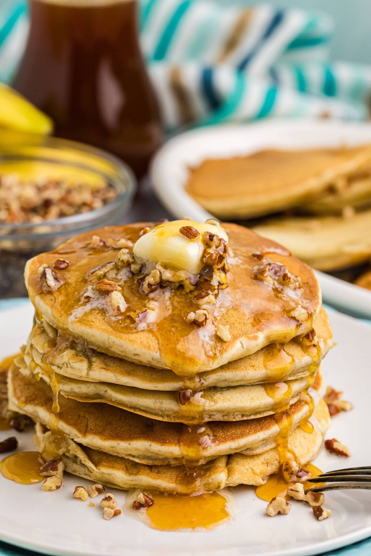 stack of banana pecan pancakes with butter and syrup