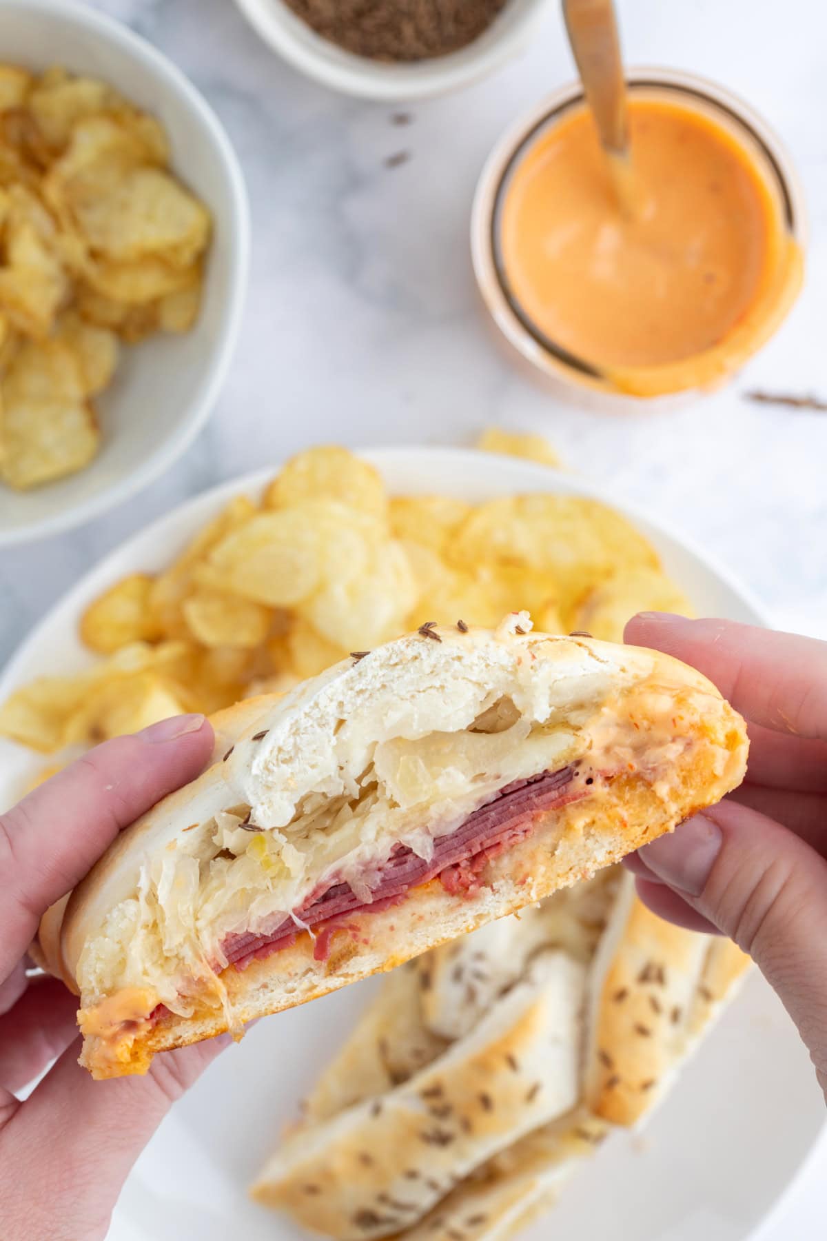 hands holding slice of reuben bread