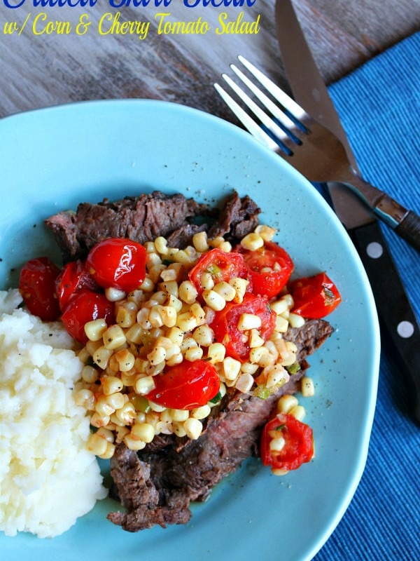 grilled skirt steak with corn and cherry tomato salad on plate