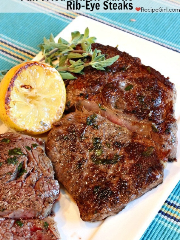 pan fried lemon-garlic rib-eye steaks on a white plate