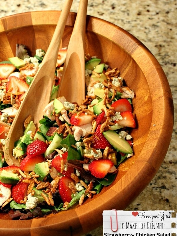 strawberry chicken salad in a big wooden bowl with wooden serving spoons