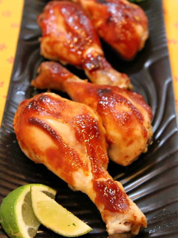 Hoisin Chicken Drumsticks with lime on brown platter