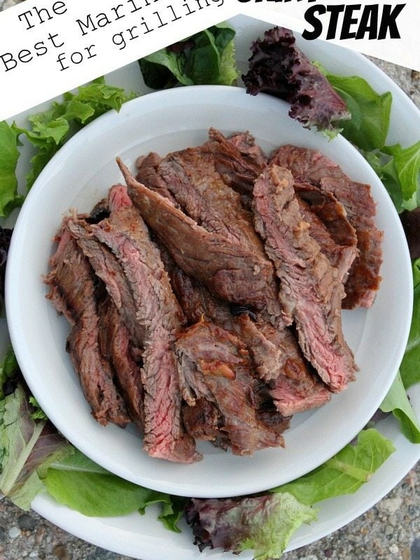 overhead shot of marinated grilled and sliced skirt steak on a white plate surrounded by lettuce leaves