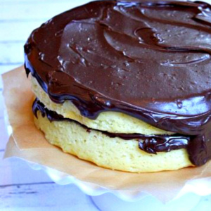 frosting a yellow cake with chocolate frosting